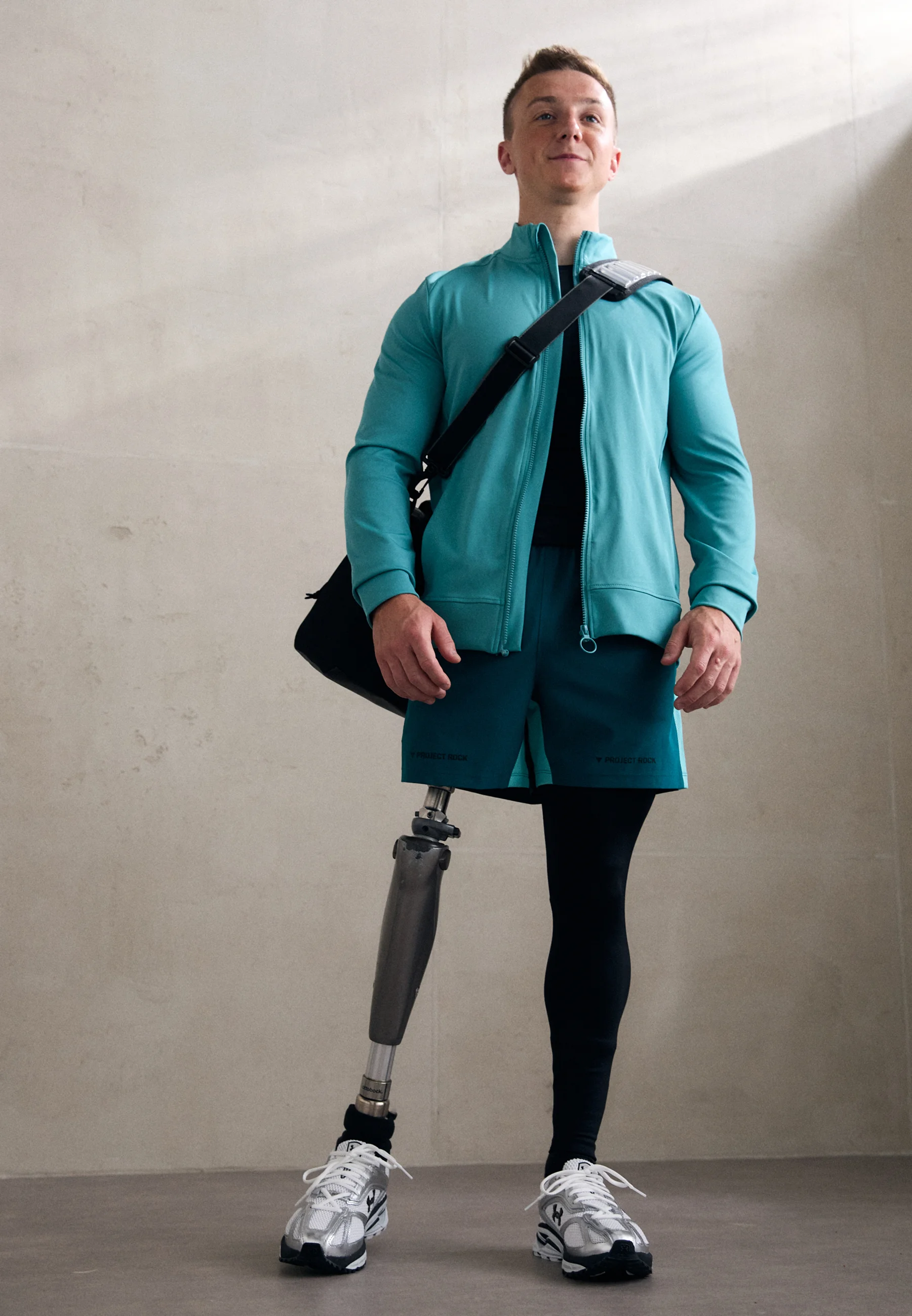 Man wears turquoise zip top with magnetic zip